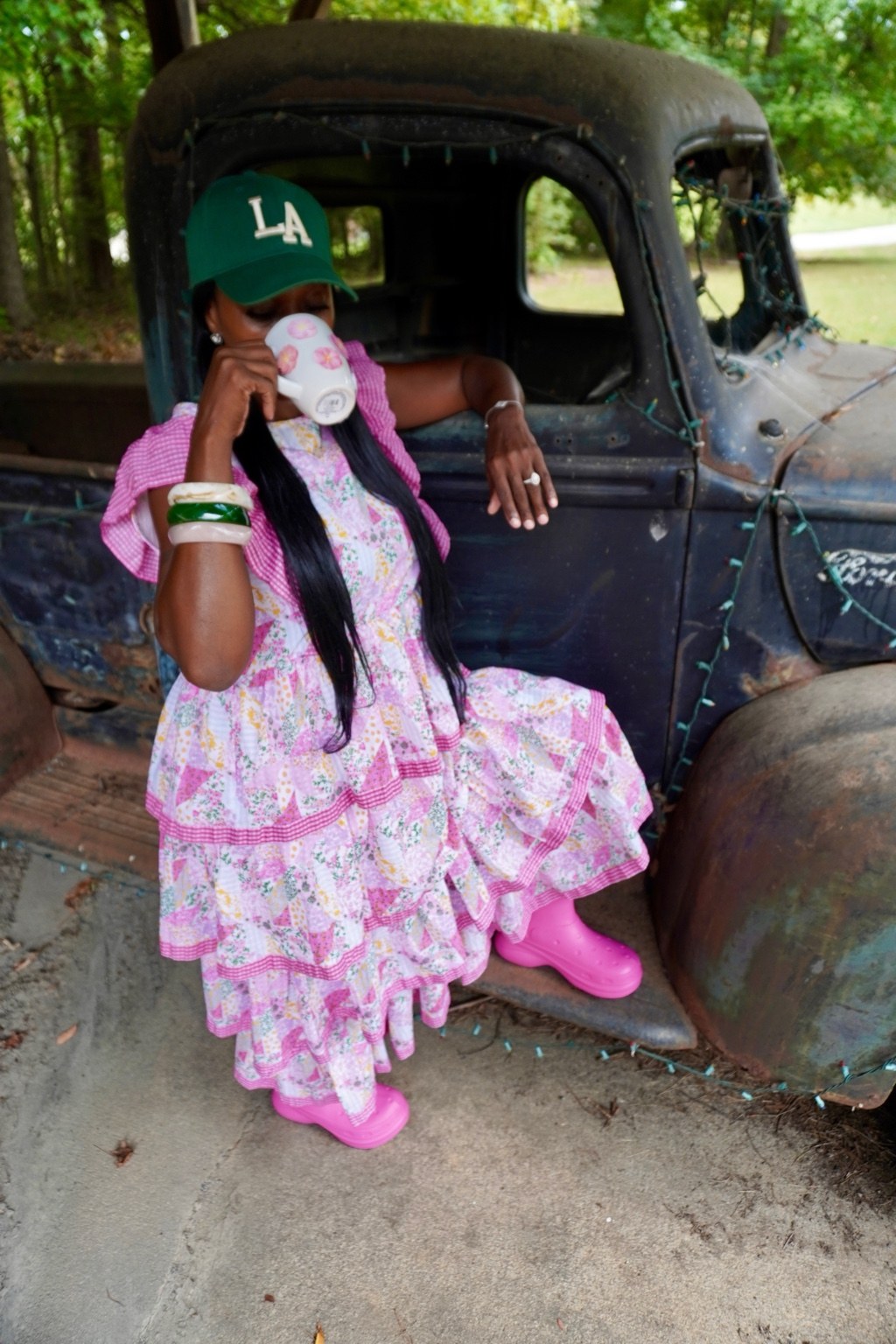 Latasha enjoying coffee during her outdoor photo shoot beside a vintage truck